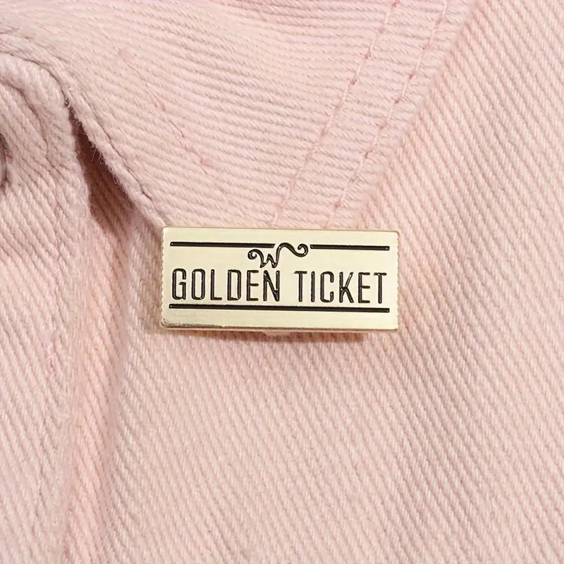 Golden ticket pin op roze spijkerjas